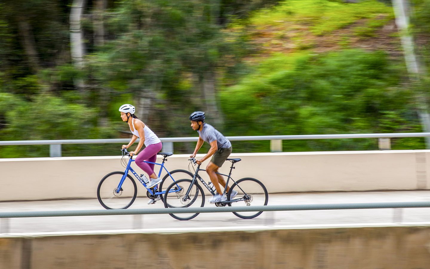 Man and woman riding new FX models across a bridge.