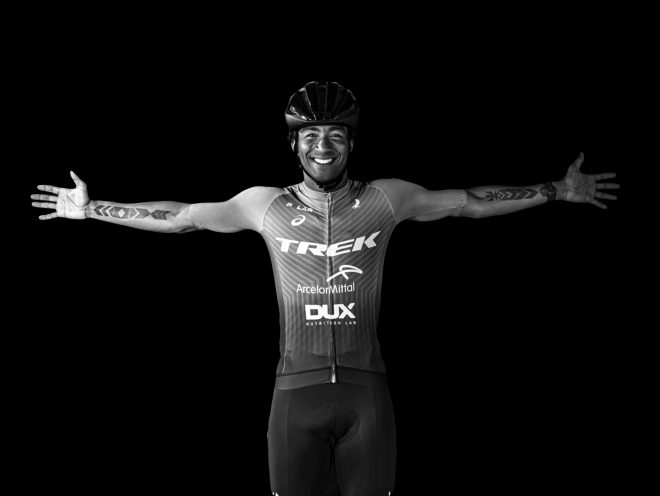 O triatleta brasileiro Thiago Vinhal com uniforme de corrida e capacete com braços bem abertos