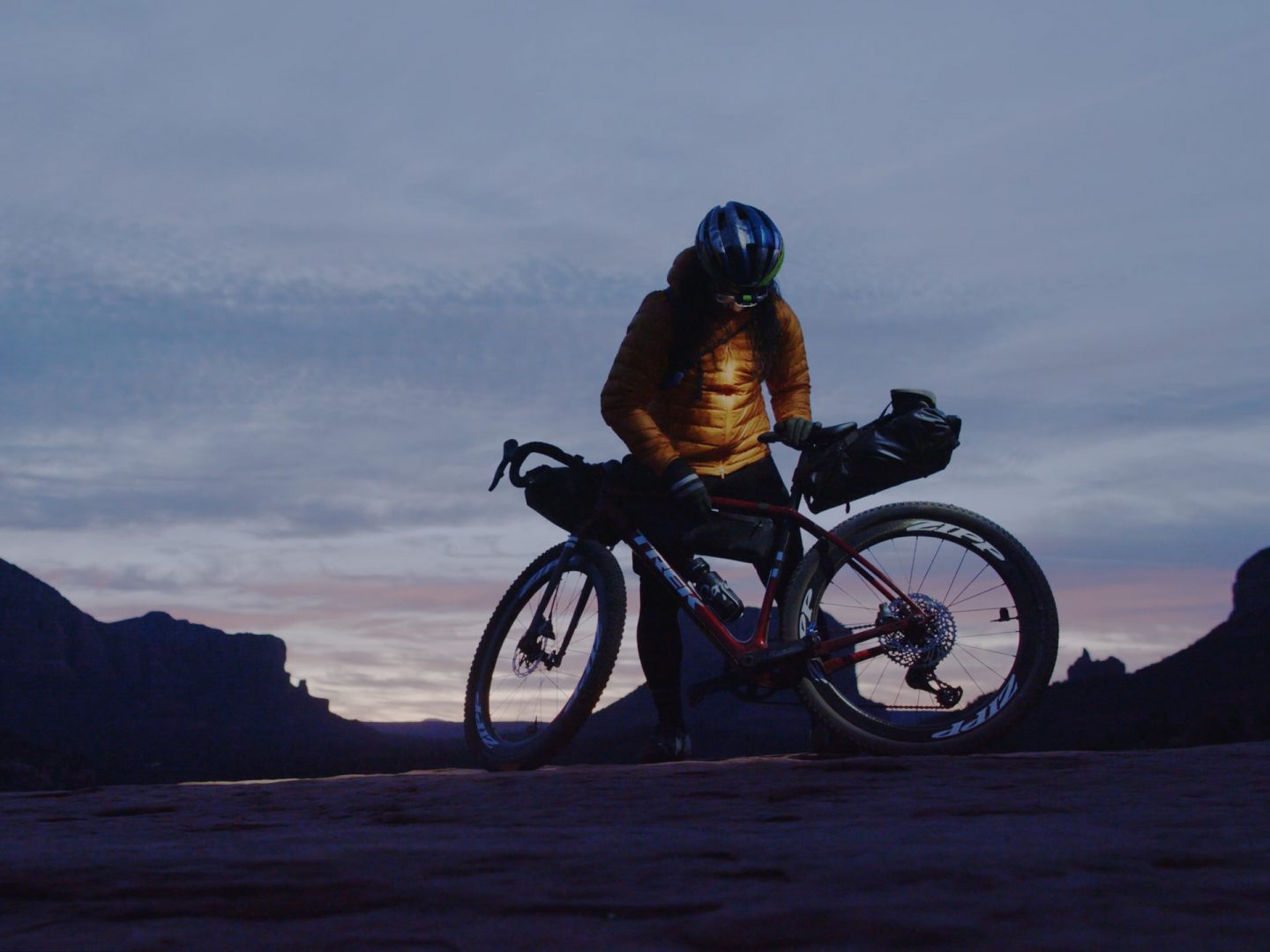 Nico Deportago-Cabrera standing beside his Trek Checkpoint and checking his gear