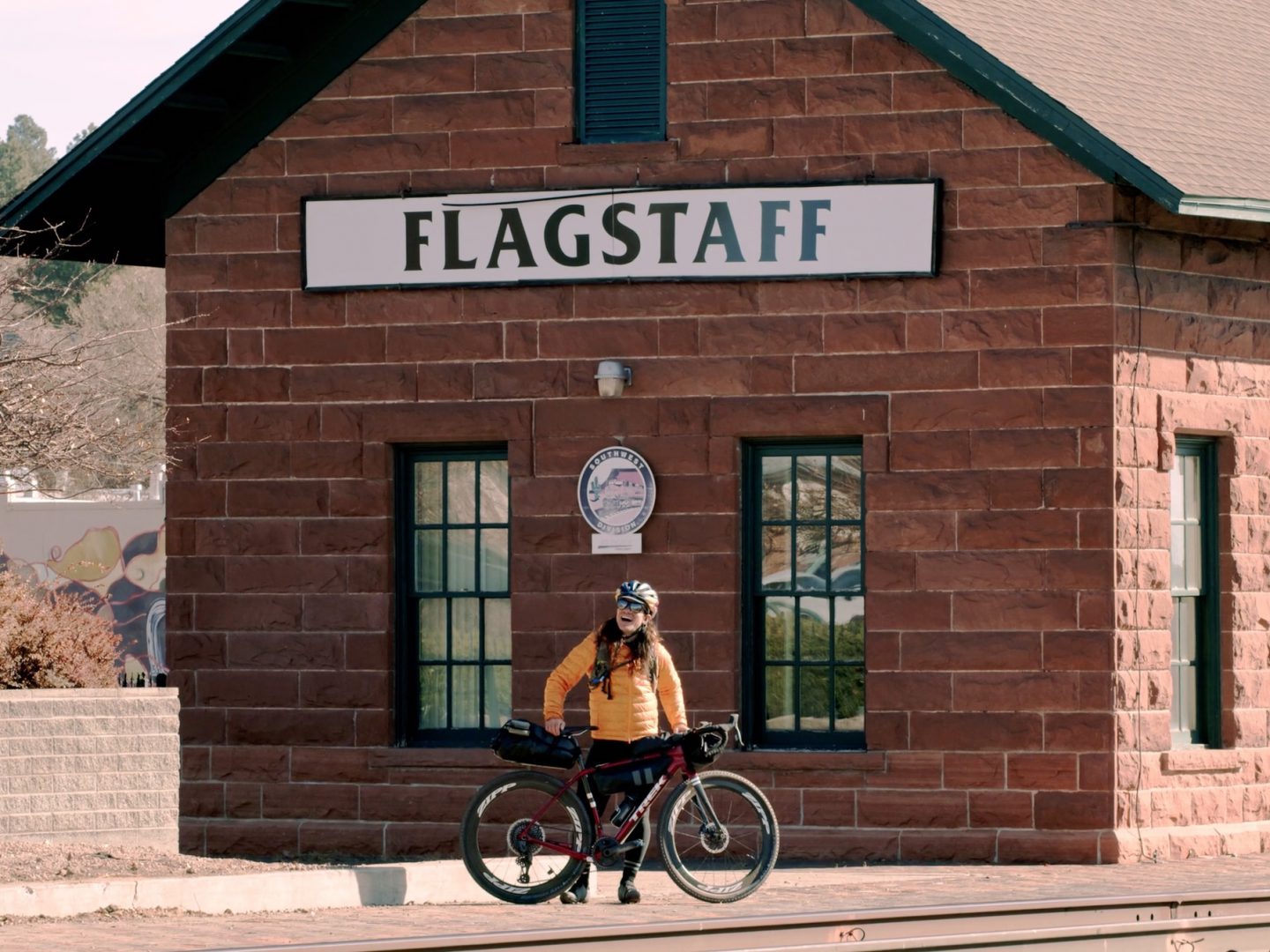 Ciclista de pé com a bicicleta na estação de comboios de Flagstaff