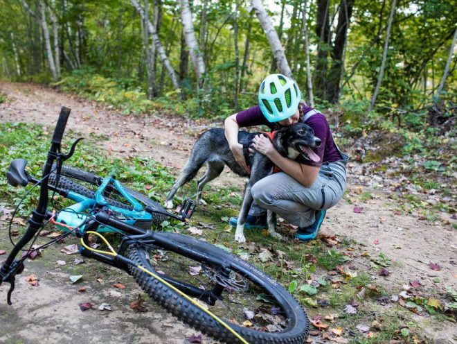 Blair Braverman abraza a uno de sus perros después de practicar el bikejoring con su Fuel EX