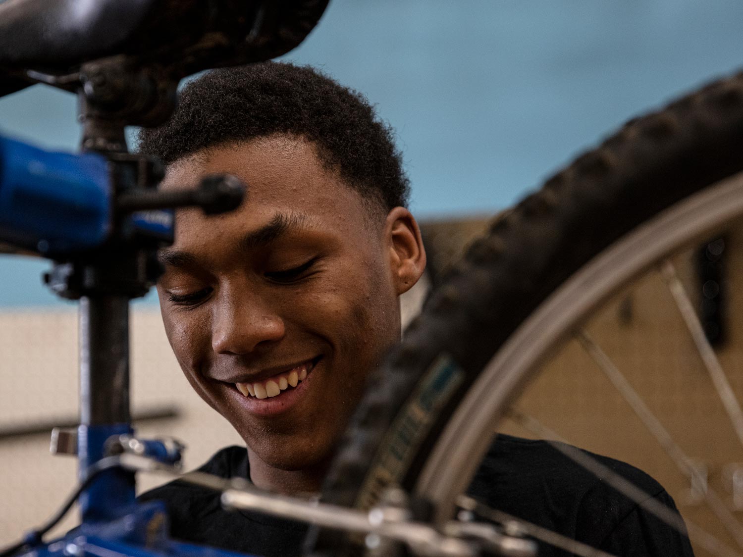 Closeup of smiling man working on a bicycle in a stand.