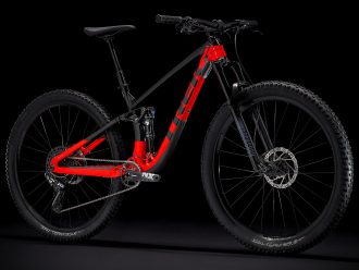 Black and red Trek Fuel EX 7 full suspension mountain bike on a black background