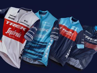 New Trek team jerseys displayed on a dark background.