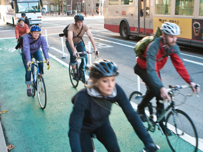 Cyclists ride in a city bike lane.