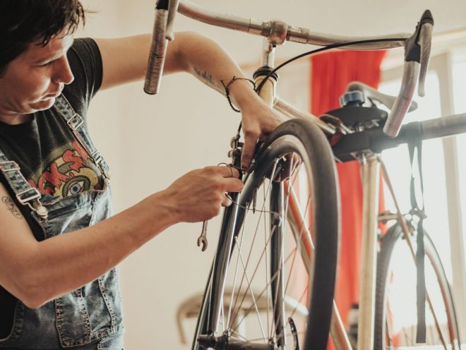 Mujer arreglando bicicleta