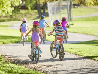 Kids riding on bike path with rear lights shining