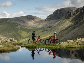 Dos ciclistas de montaña junto al agua