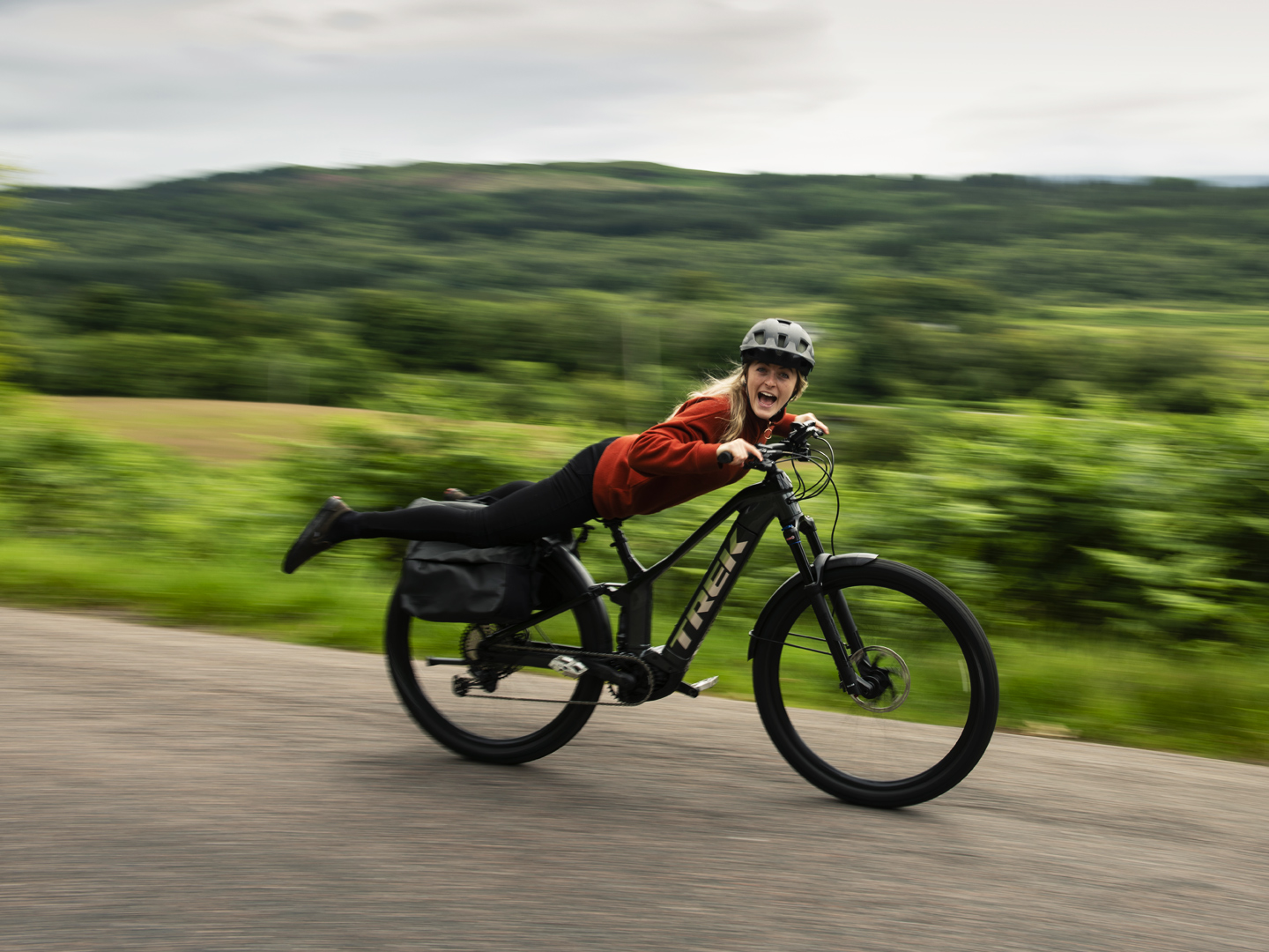 Um ciclista sorridente faz um superman com a sua bicicleta