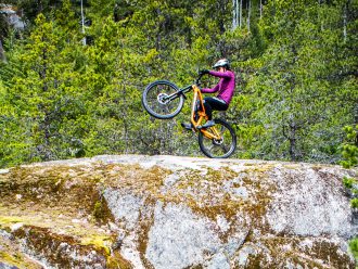 Christina Chappetta doing a wheelie on the top of a large rock