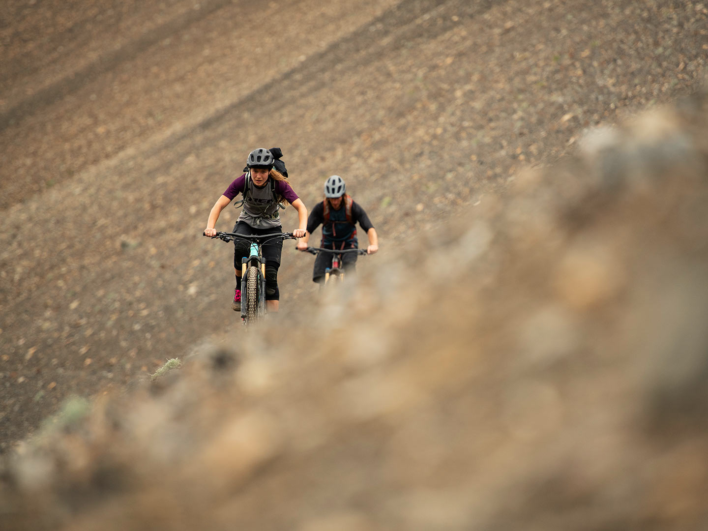 Ciclistas subiendo un sendero a gran altura, por encima de la línea de los árboles.