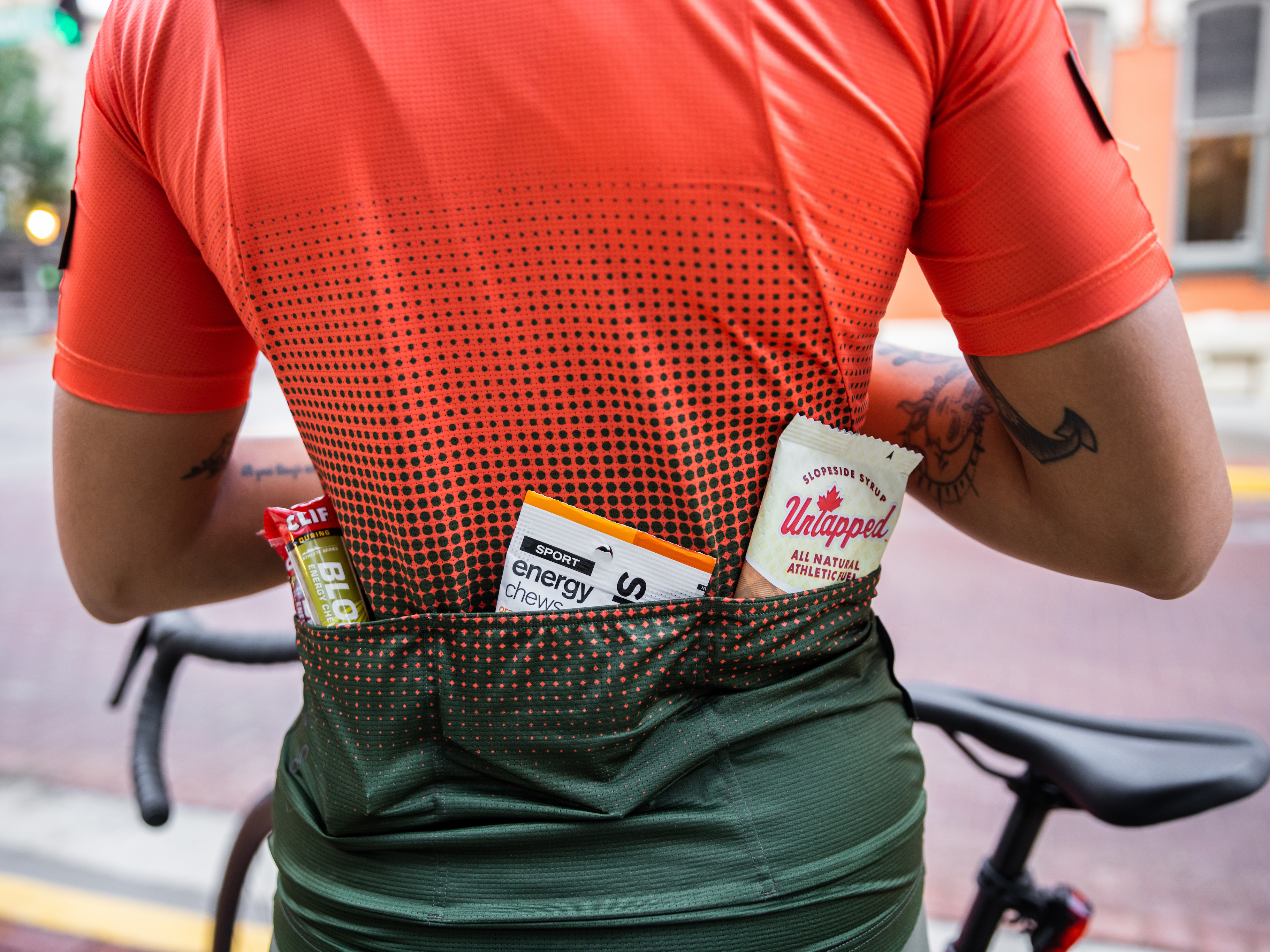Bolsos de trás de um ciclista com géis, gomas e barras de granola