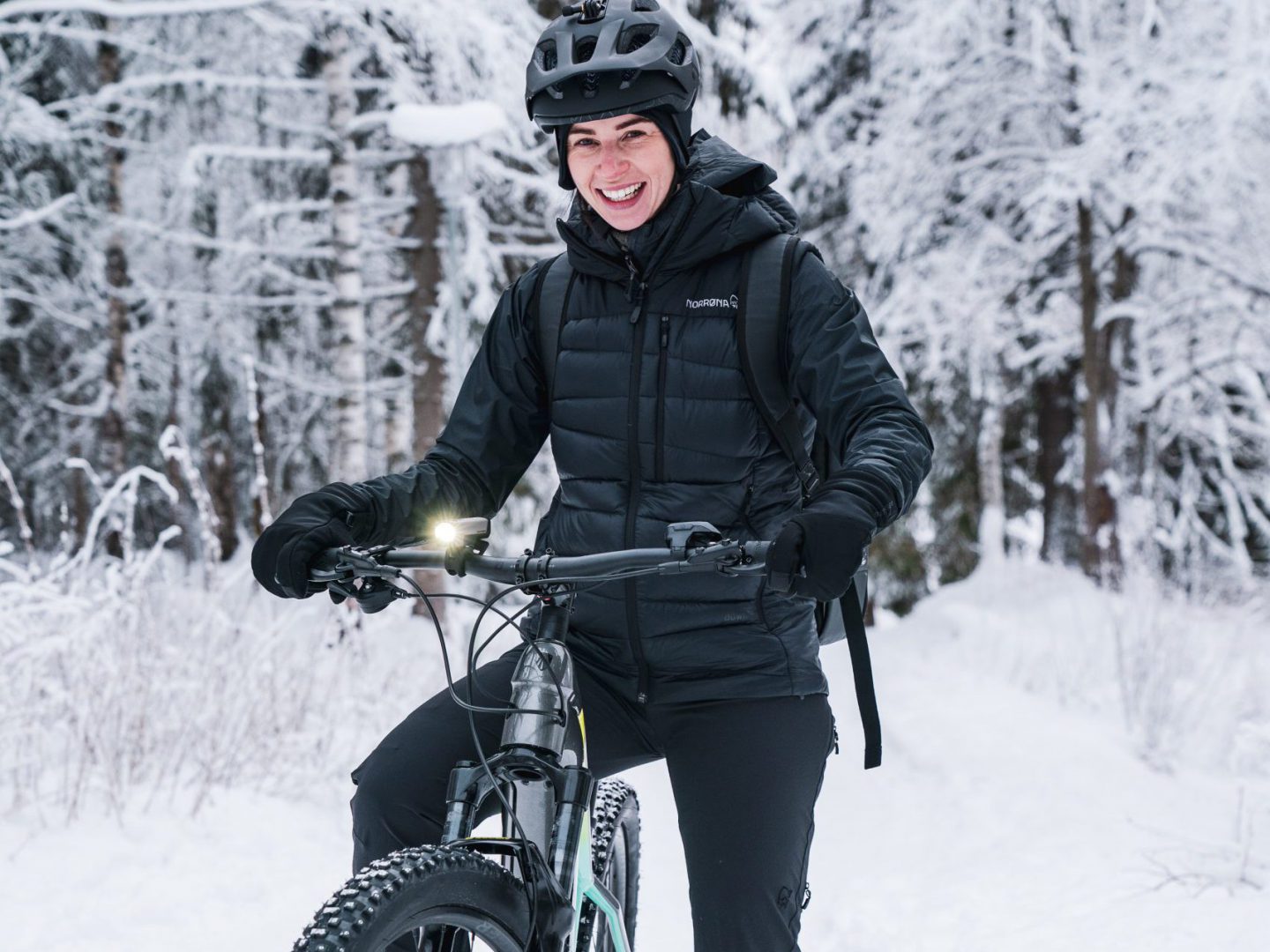 Glad cyklist som cyklar på vintern