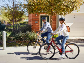 Ciclistas hombre y mujer pedaleando por la calle en bicicletas urbanas