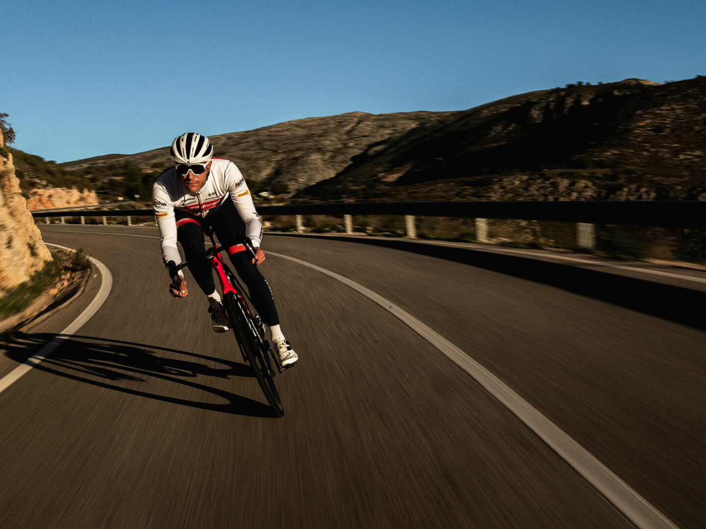 Trek-Segafredo-rytter cykler på en nedkørsel i bjergene med kroppen i aeroposition.