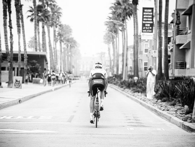 James riding in southern California with palm trees in the background.