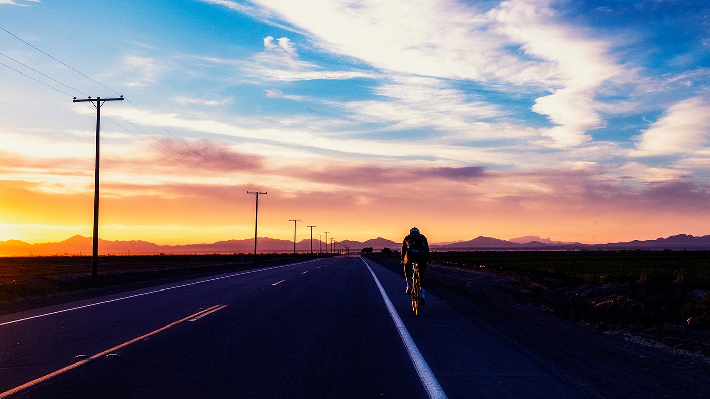 James Golding cyklende i ørkenen ved solnedgang i det sydvestlige USA.