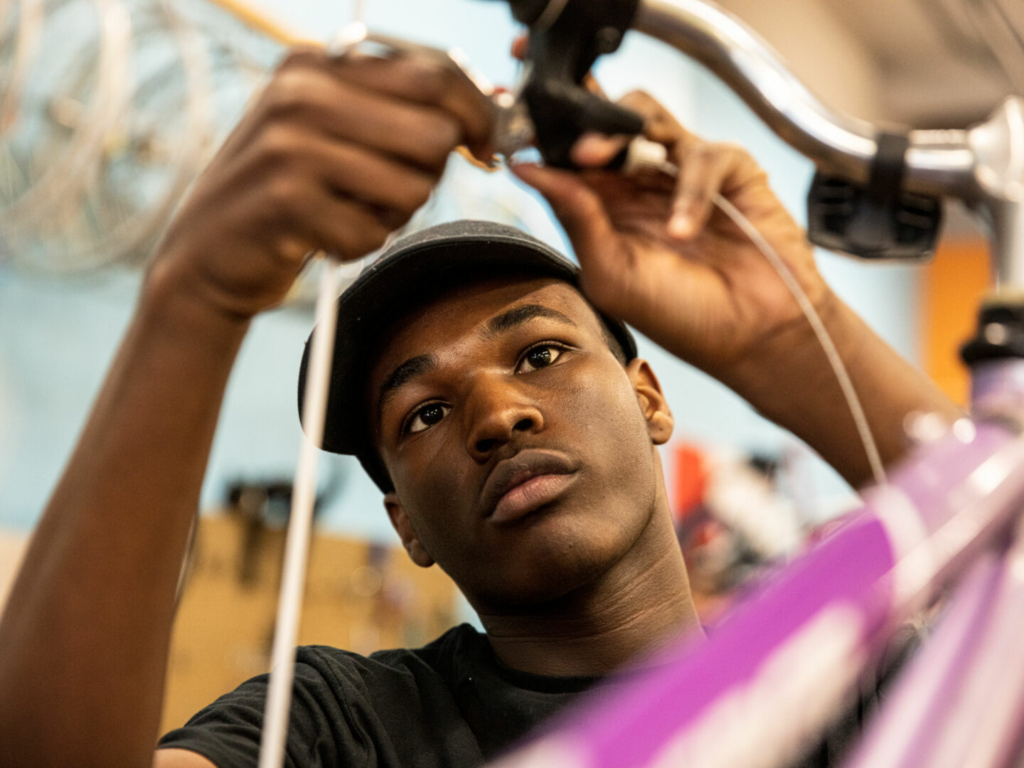 A young man looks focused while working on a bike.