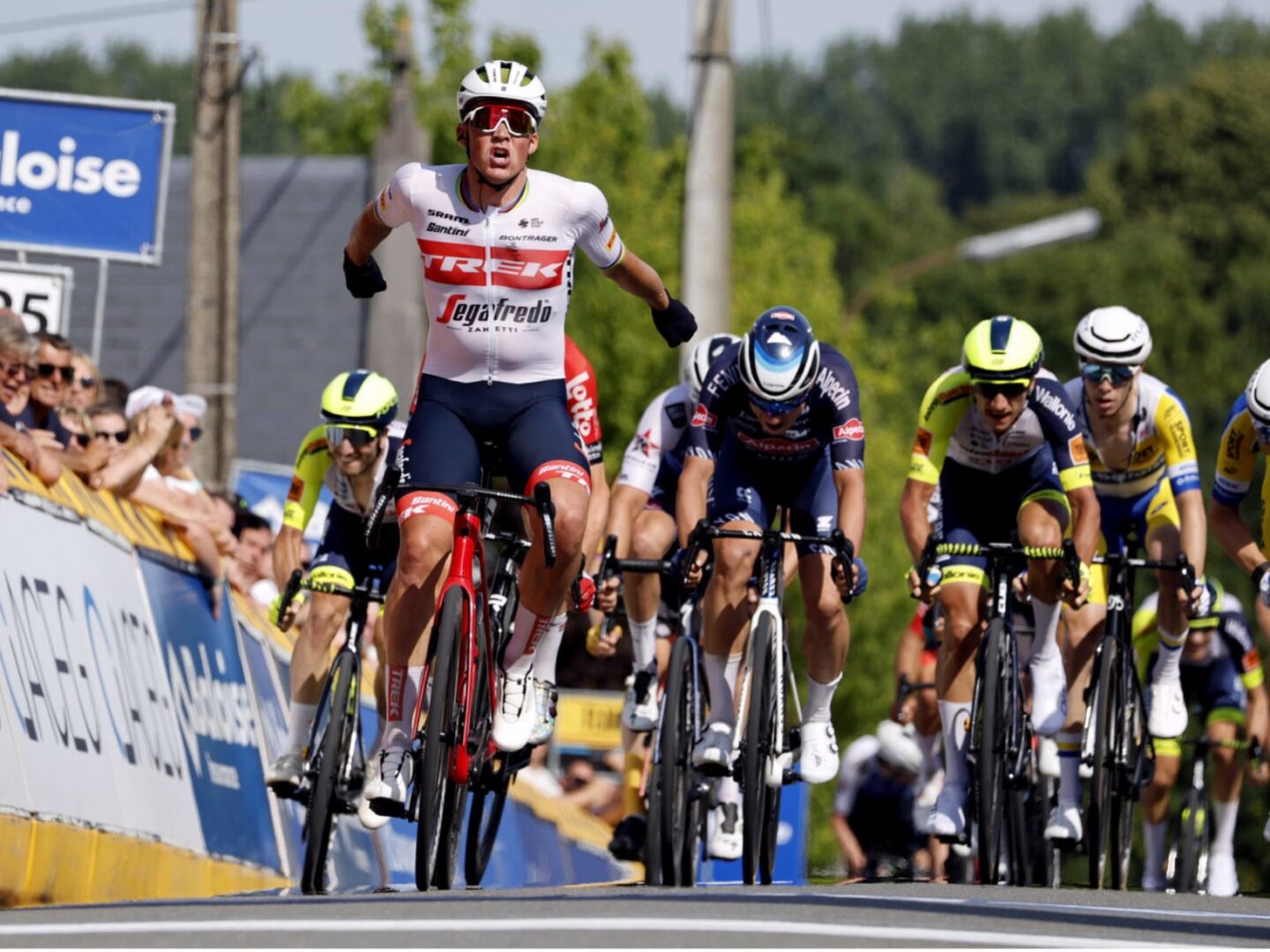 Mads Pedersen gooit zijn handen in de lucht na een overwinning