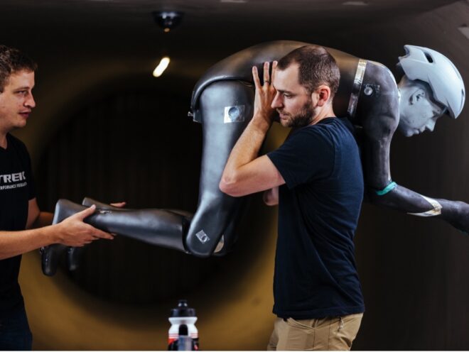 Two people carrying a mannequin in a riding position 