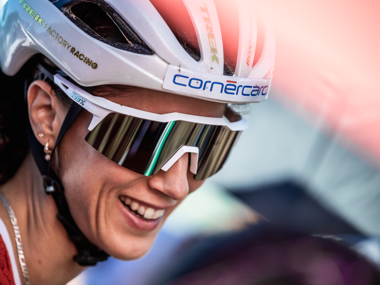 Jolanda Neff smiling with sunglasses and a helmet on.