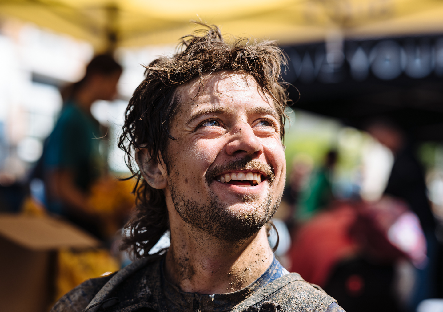 Kiel smiles with a muddy face a messy hair after finishing UNBOUND gravel race.