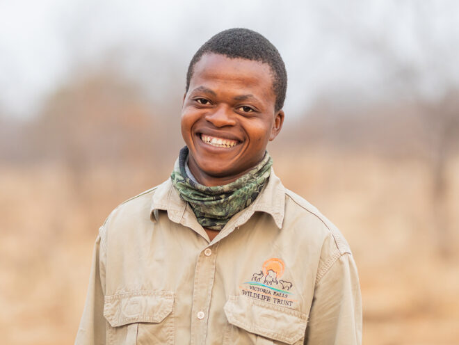 Levison wearing his conservation ranger uniform and smiling at the camera.