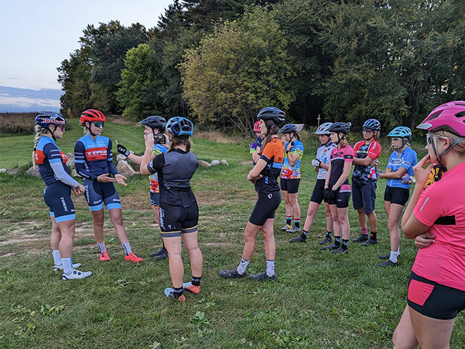 A GRiT rider interviews Evie Richards and Madigan Munroe while other riders look on