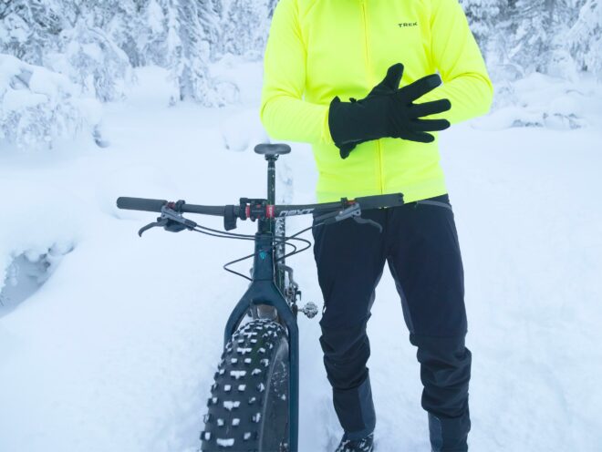 Mountainbikeförare med sin Trek Farley fatbike i en snöig skog.