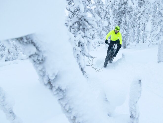 En mountainbike rytter på en Trek fatbike i en snedækket skov.