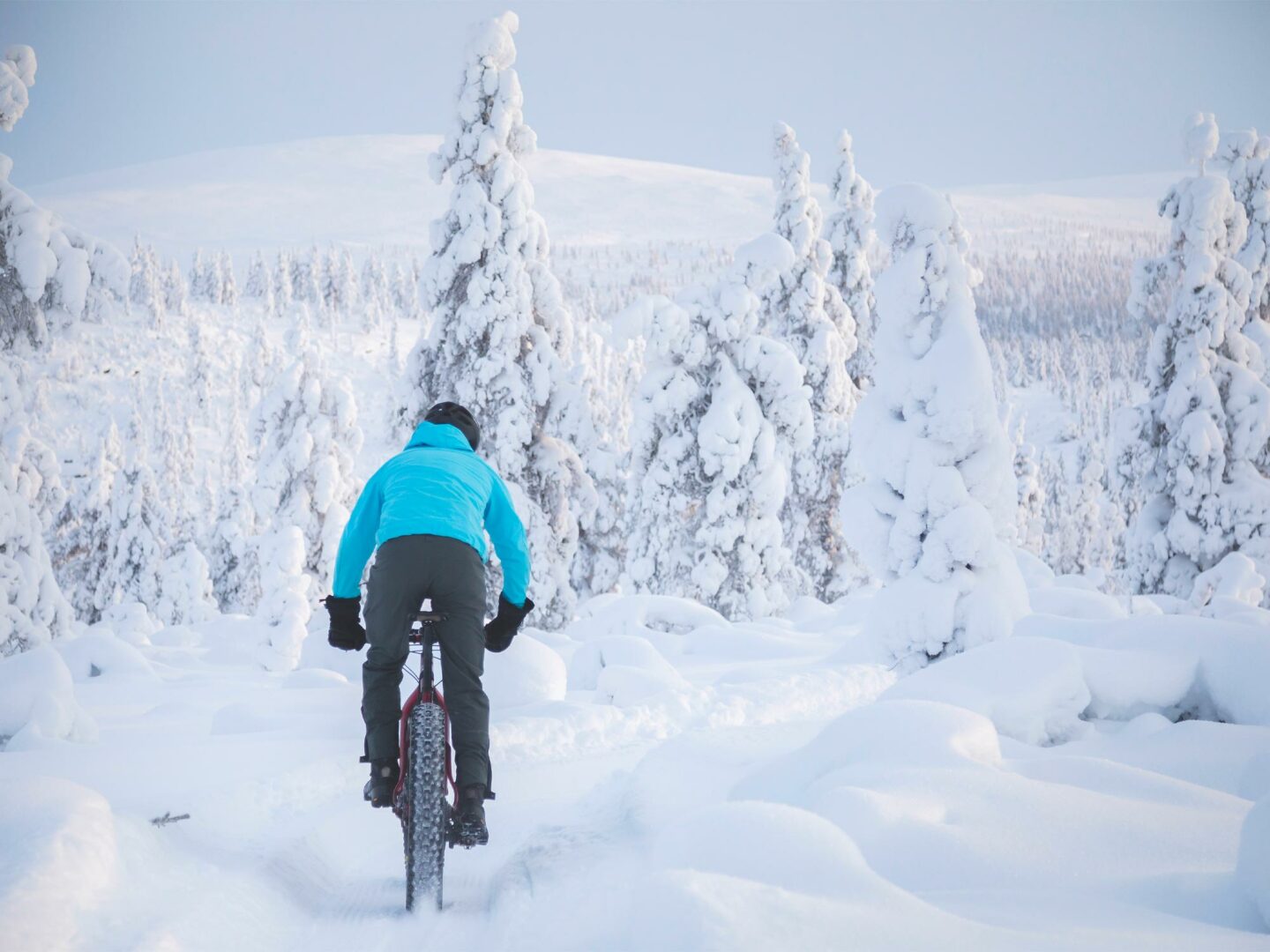 Bild av en mountainbiker som cyklar på en snöig stig