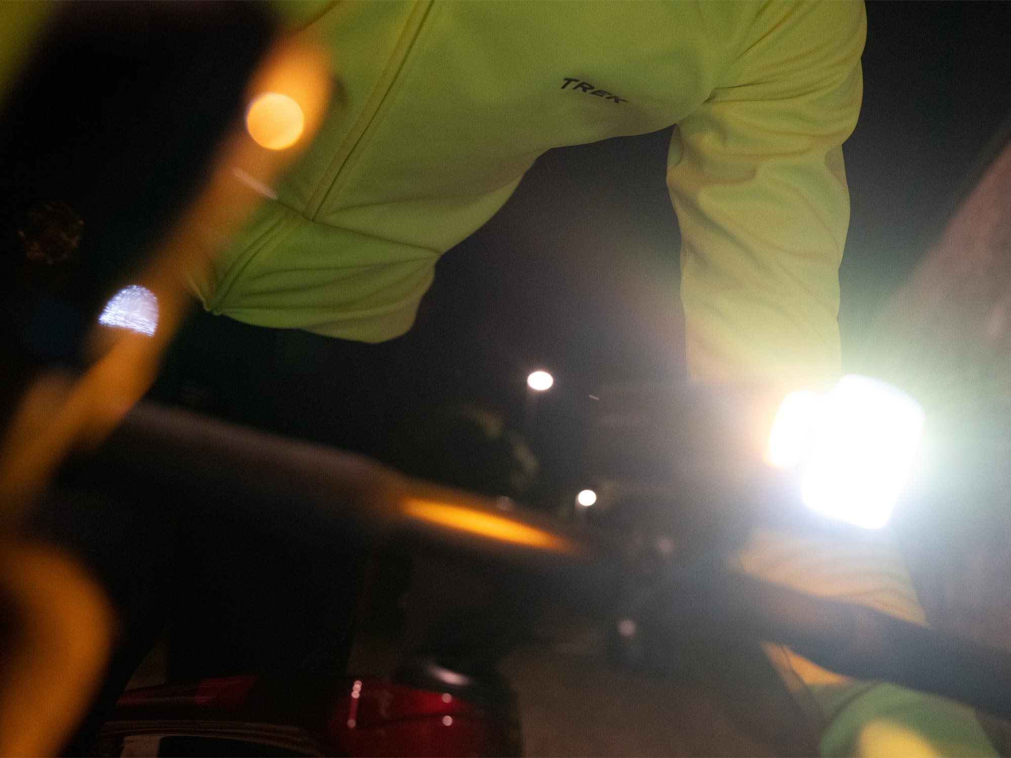 Lähikuva pyöräilijästä, jolla on kirkas valo kiinnitettynä ohjaustankoon.