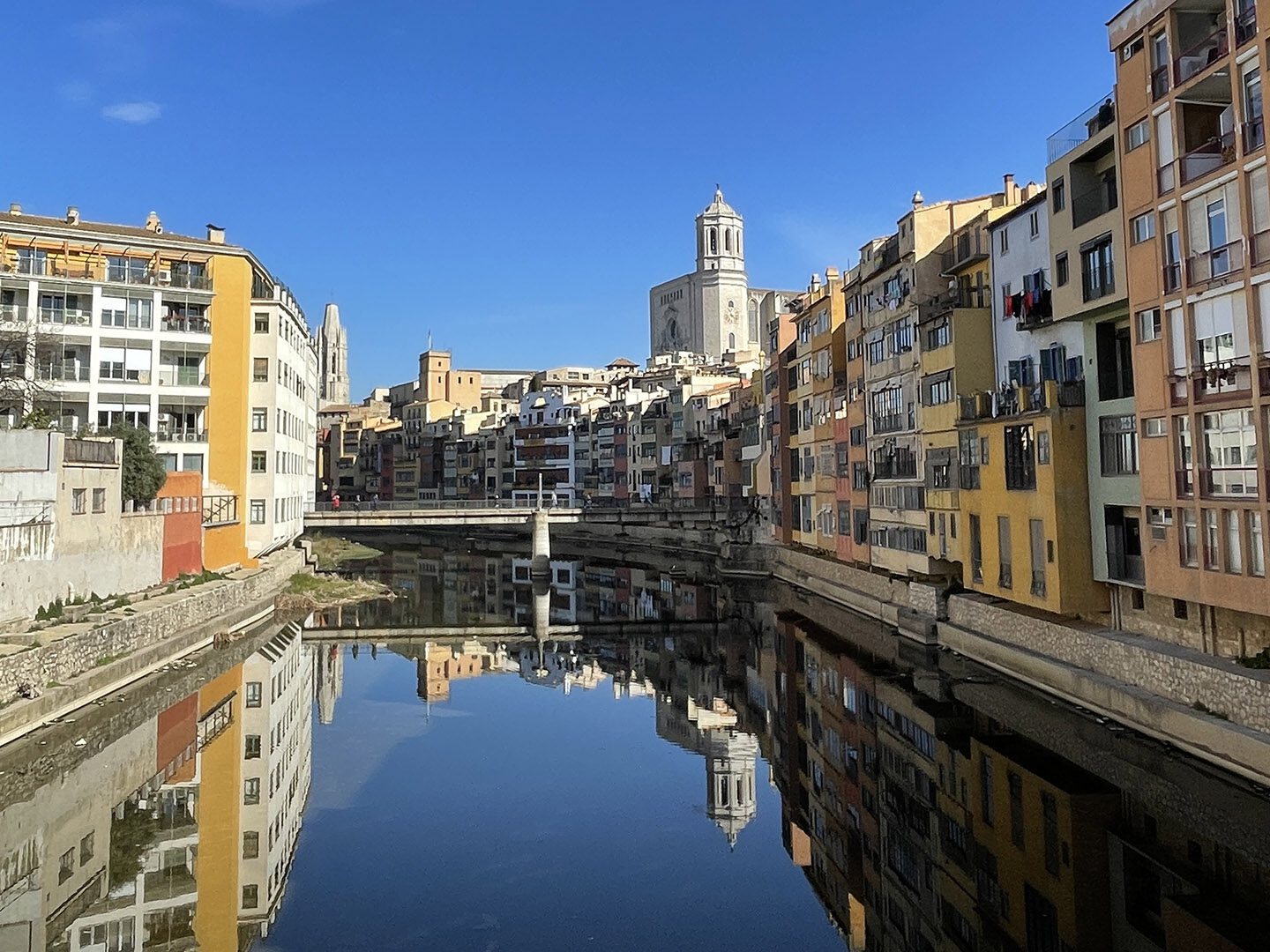 Colorful old buildings lining a river in Girona.