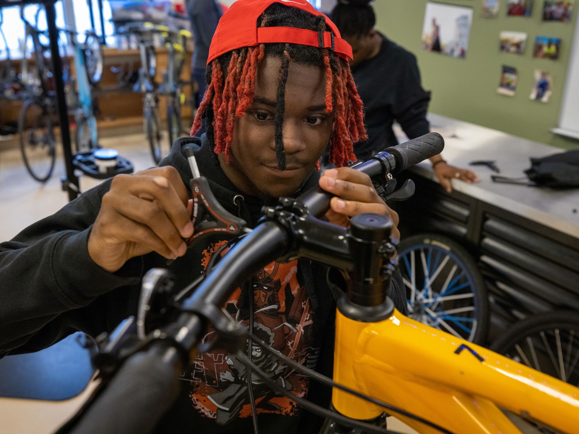 A student wrenches on a mountain bike handlebar during in-store tech class.