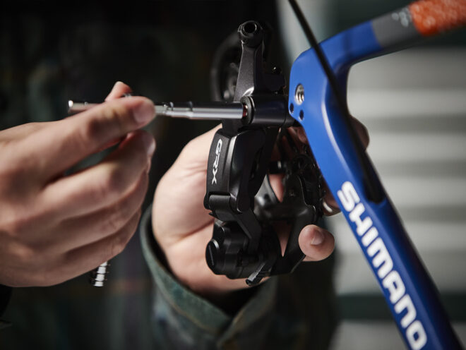 A mechanic installs the Shimano GRX rear derailleur on the United in Gravel Checkpoint SLR.