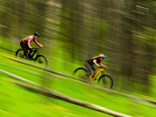 Two mountain bikers descend a steep trail.